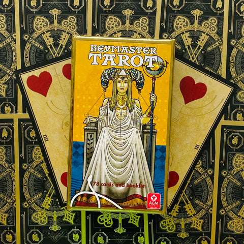 Tarot kortos Keymaster geltoname dėkle, 78 kortų rinkinys, matomas dėklo priekinis piešinys ant ornamentinio fono
