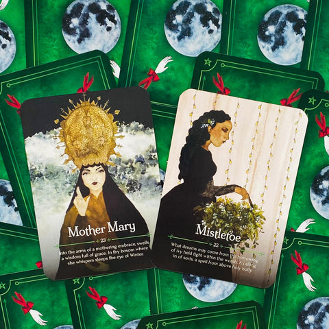Tarot kortos su žalia nugarėle — dvi atidengtos kortos Mother Mary ir Mistletoe parodytos iš viršaus, pabrėžiant skirtingus dizainus