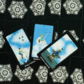 tarot kortos Rider Waite stiliaus rinkinys, trys kardų rūmų kortos išdėstytos skersai ant juodos mandalos nugarėlės