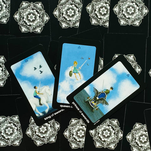 tarot kortos Rider Waite stiliaus rinkinys, trys kardų rūmų kortos išdėstytos skersai ant juodos mandalos nugarėlės