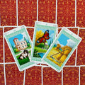 tarot kortos Pentacles, trys žalti rėmeliai su atverstomis 8–10 kortomis ant raudono ornamentuoto nugarėlių fono