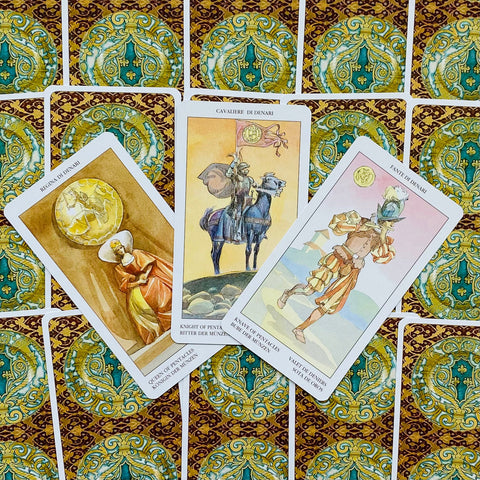 Tarot kortos su monetų rūšies figūromis — trys kortos iš viršaus parodytos ant ornamentinių nugarėlių, skirtingi variantai