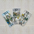 Tarot kortos vintage stiliaus, trijų kortų išdėstymas ant rausvo raštuoto fono, aiškios iliustracijos