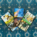 tarot kortos komplektas su trimis lazdomis (6, 7, 8) — spalvingos figūros ir mėlynas saulės raštuotas fonas