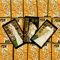 tarot kortos Klimto stiliaus, trys atverstos kortos su auksinėmis detalėmis ant raštuotų auksinių nugarėlių