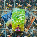 Fairy Lights Tarot kortos, žalia dėžutė su spiraliniu raštu padėta ant atvertų iliustruotų kortų fone, aut. Lucia Mattioli