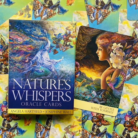 Oracle kortos Nature's Whispers dėžutė su viena atversta korta, matoma iliustracija ir patarimas Būk švelnus sau, ryškios spalvos