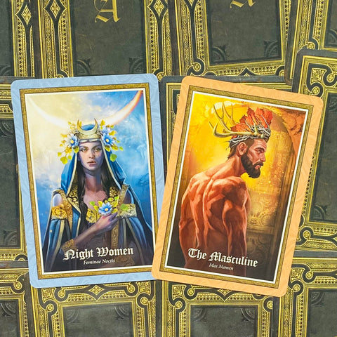Tarot kortos parodo dvi priekinės kortas iš viršaus: mėlynos "Night Women" ir oranžinės "The Masculine" su ornamentuotu kortų fone