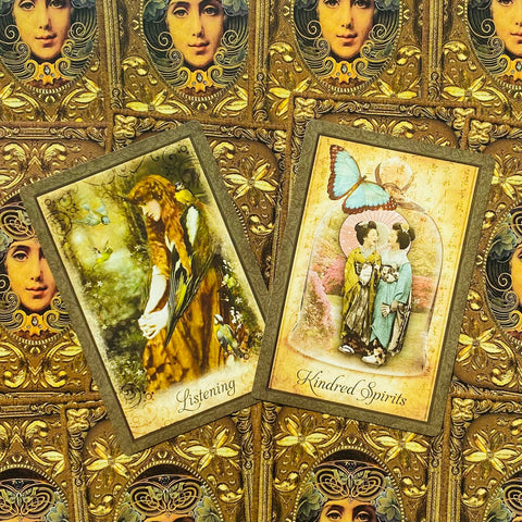 Tarot kortos priekiniai dizainai „Listening“ ir „Kindred Spirits“ ant auksinio ornamentuoto fono, kampu sukryžiuotos