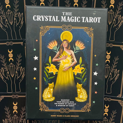 Priekinis The Crystal Magic Tarot denio juodos pakuotės vaizdas su geltonomis moters ir kačių iliustracijomis, arti centro, išsiskiria dekoratyviu fonu