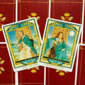 Taro kortos — King ir Queen of Cups kortų priekinės pusės, žalsvai mėlynos aprangos detalės ir raudonos nugarėlės