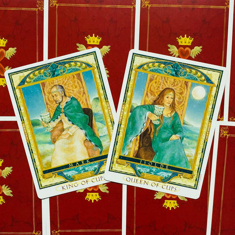 Taro kortos — King ir Queen of Cups kortų priekinės pusės, žalsvai mėlynos aprangos detalės ir raudonos nugarėlės
