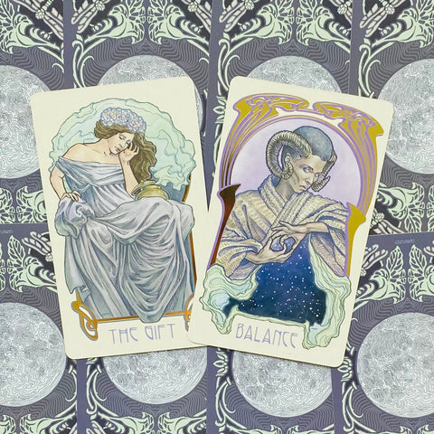 Tarot kortos su dviem atvertais kortomis „The Gift“ ir „Balance“, meninė mėlynos–lila paletė ant ornamentuoto nugarėlių fono