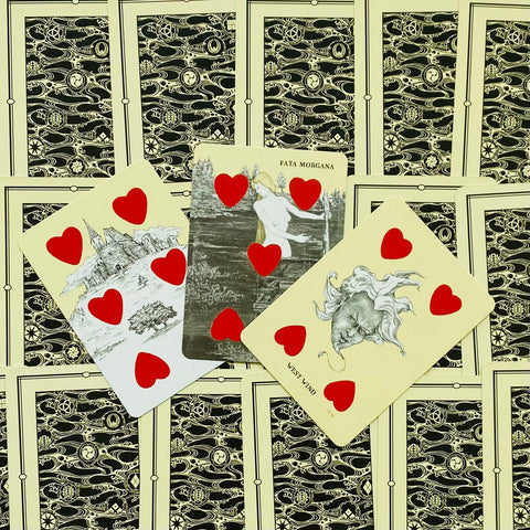 Tarot kortos trys atvertos kortos su raudonomis širdimis, Fata Morgana ir West Wind iliustracijomis ant nugarėlių fono