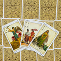 tarot kortos vintage stiliaus, trys atverstos kortos su smėlio ir žaliais piešiniais ant aukso raštuotų nugarėlių