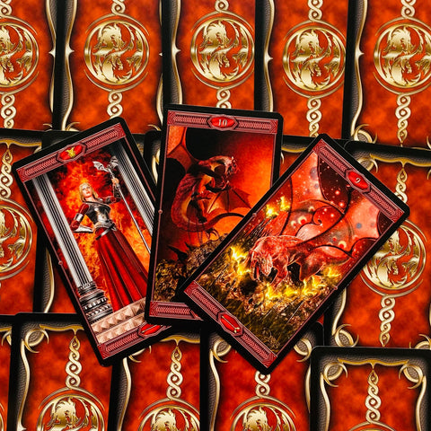 Tarot kortos su raudonomis drakonų iliustracijomis — trys atvertos kortos ir aukso raštuotos nugarėlės