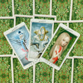 Tarot kortos su iliustruotais priekiais — trijų kortų kompozicija, dengianti žaliu nugarėlių raštu su raudonomis uogelėmis
