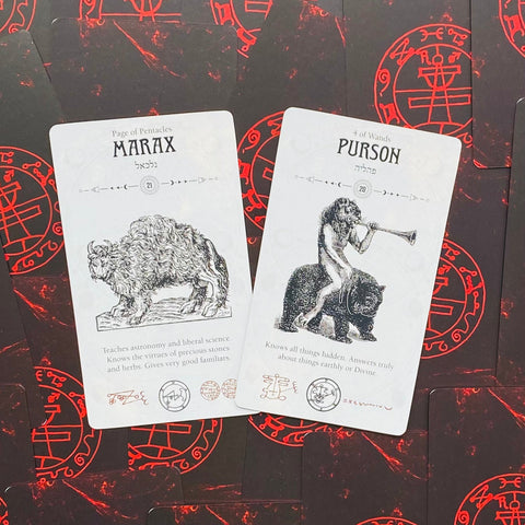 tarot kortos baltos iliustruotos kortos Marax ir Purson ant raudonai juodų nugarėlių, artimas kampas pabrėžia detales