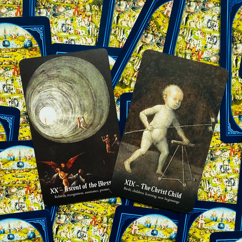 Tarot kortos rinkinio dvi atverstos kortos su meniniais tamsiais piešiniais ir ryškiai mėlynais nugarėliais, skirtos prekės peržiūrai