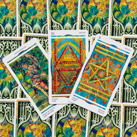 Tarot kortos spalvingos lazdų serijos: trys kortos išsidėstę ant ornamentuotų nugarėlių, pabrėžtas lazdų motyvas