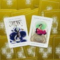 tarot kortos su baltomis priekėmis ir auksinėmis nugarėlėmis, dvi atverstos kortos Ace of Swords ir Keeper of Pentacles, fotografuota iš viršaus