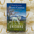 Stalo žaidimas The Wonder of Unicorns – Diana Cooper leidimas, priekinė dėžutės viršelis su balta vienaragio iliustracija ir gėlių fonu