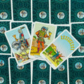 Tarot kortos Rider‑Waite stiliaus, trys taurų rūšies kortos išmėtytos virš žalsvų ornamentuotų nugarėlių