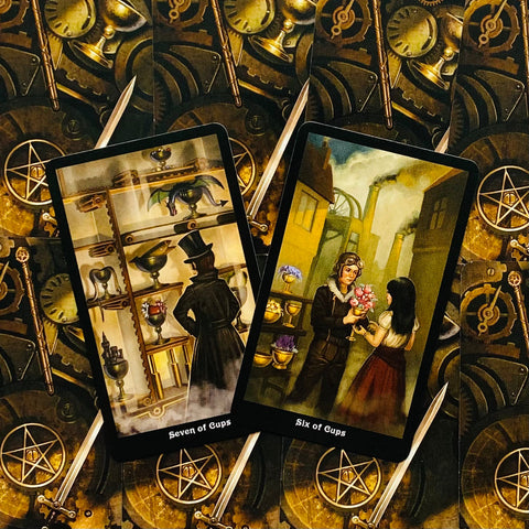 tarot kortos su steampunk nugarėle, dvi atverstos kortos (Septynios taurės, Šešios taurės) pasvirusiu kampu, detalūs priekiai