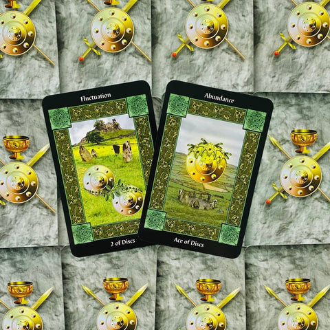 Taro kortos su žaliais rėmeliais – parodytos Ace of Discs (Abundance) ir 2 of Discs (Fluctuation), prieš nugarėles