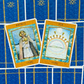 tarot kortos – atviros „Prince“ ir „Ten of Cups“ kortos su gintaro rėmais, pakryžiuotos ant mėlyno nugarėlių rašto