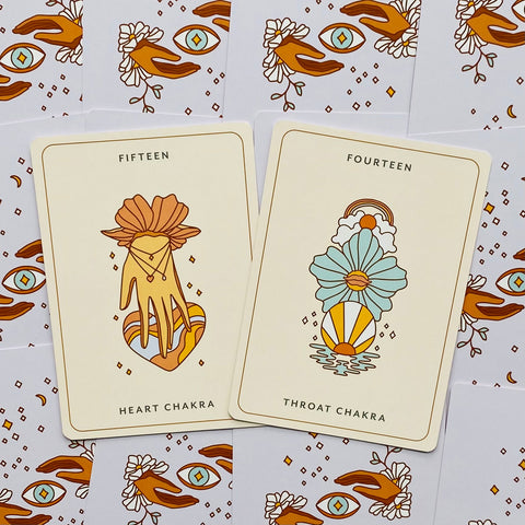 Chakrų kortos: dvi kortos ant kreminio fono — Heart Chakra su oranžiniais akcentais ir Throat Chakra melsvai‑geltonu motyvu
