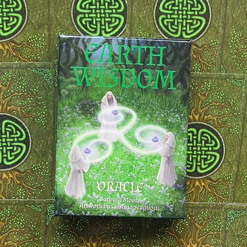 Earth Wisdom oracle kortos, žalia dėžutė su mistiniu miško viršeliu, nufotografuota iš priekio ant keltų kortų fono