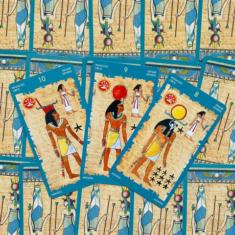 tarot kortos egiptietiško stiliaus su turkiškomis kraštinėmis — artimas trijų Pentaklių (8–10) kortų fragmentas ant kartotinio fono