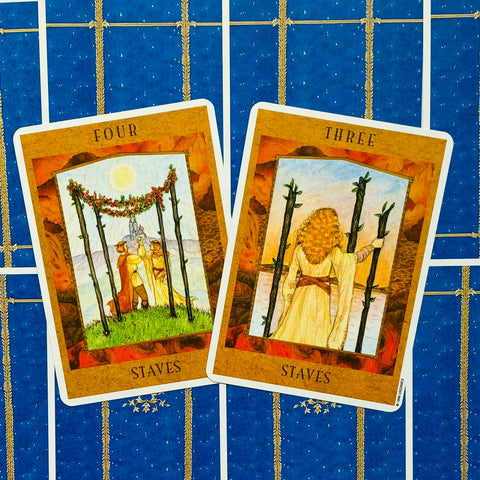 Tarot kortos dvi atverstos Staves (Three ir Four) kortos ant mėlyno ornamentuoto nugarėlio, pasuktos skirtingais kampais