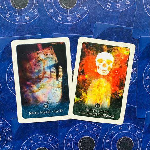 tarot kortos dvi atverstos su ryškiomis kosminėmis iliustracijomis (32 ir 33), guli ant mėlyno zodiako fono