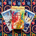Tarot kortos Wheel of the Year – spalvinga dėžutė su moters iliustracija ir dviem kardų kortomis, fone ratai ir saulėgrąžos
