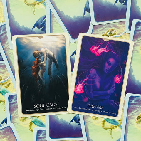 Tarot kortos su „Soul Cage“ ir „Dreams“ iliustracijomis, artimas kadras rodo kortų priekį ir spalvingą nugarėlę