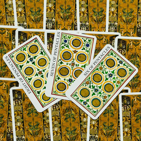 Tarot kortos su ornamentinėmis auksinėmis nugarėlėmis ir ryškiai dekoruotais penkiakampių priekiais, rodomas galimų kortų variantas