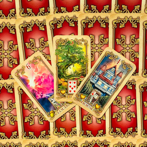 Lenormand kortos su raudona auksuota nugarėle ir trimis ištrauktomis kortomis (Debesys, Medis, Namas) šiek tiek pasvirusios, skirtos introspekcijos sklaidai
