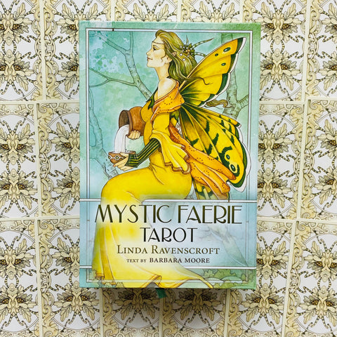 Mystic Faerie Tarot kortų rinkinys — Linda Ravenscroft pakuotės priekinis viršelis su geltona fėja ant ornamentinio fono