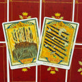 Tarot kortos su atverstomis devynike ir aštunike lazdelėmis ant raudonų nugarėlių, priekiniai dizainai matomi