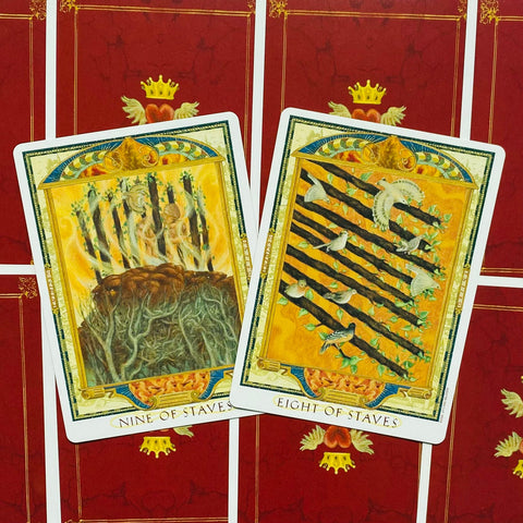 Tarot kortos su atverstomis devynike ir aštunike lazdelėmis ant raudonų nugarėlių, priekiniai dizainai matomi