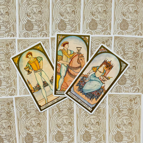 tarot kortos vintage stiliaus: trys taurų kortos (paikas, riteris, karalienė) išdėstytos ant smėlio spalvos ornamentuotų nugarėlių