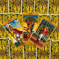 Tarot kortos – trijų kortų išklotinė su auksinėmis nugarėlėmis, šviesios spalvos Lazdų kortos parodytos centre ir šone