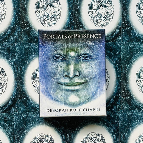 Kortų kaladė Portals of Presence (Deborah Koff‑Chapin), mėlyna mistinė veido iliustracija, fotografuota iš viršaus ant raštuoto fono