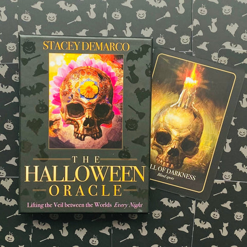 Halloween orakulas Stacey Demarco, juoda dėžutė su spalvota kaukolės iliustracija ir dešinėje atversta Skull of Darkness korta