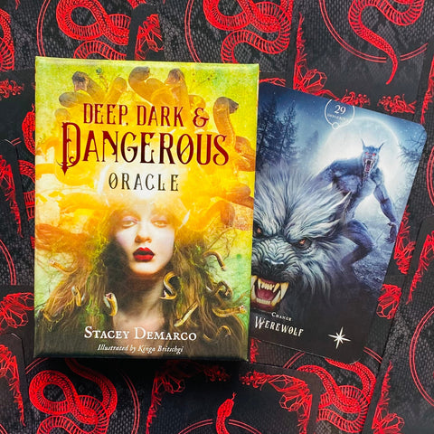 Deep, Dark & Dangerous oracle kortų rinkinys su geltonu dėklu priešakyje ir šalia ištraukta įniršusi vilkolakio korta