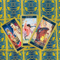 tarot kortos Rider–Waite stiliaus komplektas, trys atverstos Wands kortos (Queen, Knight, Page) ant mėlyno aukso rašto fono