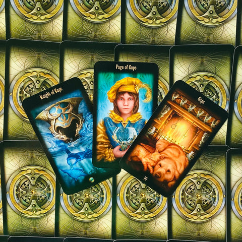 Tarot kortos – trijų atverstų kortų kompozicija: mėlynas Riteris, geltonasis Taurių puslapis ir oranžinė 10 prie židinio