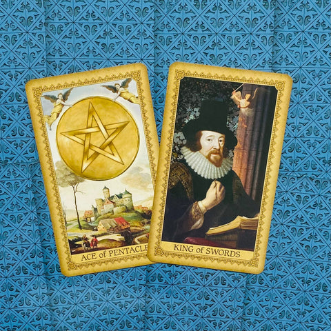 tarot kortos klasikiniu dizainu — atverstos Ace of Pentacles ir King of Swords ant mėlyno raštuoto fono